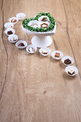 Chocolate pralines on wood, text space