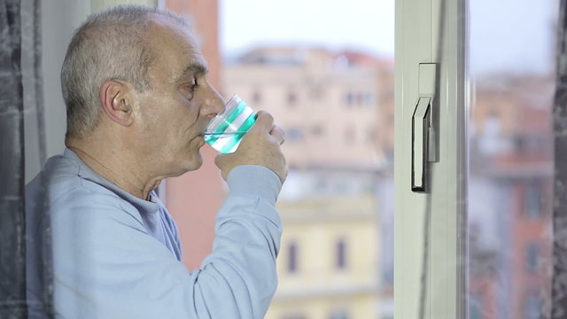 old man quenches his thirst by drinking water very quickly