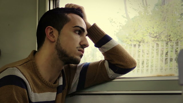 Traveling by train. Man traveling by train, looking through the dirty window