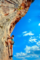 Rock climber climbing up a cliff