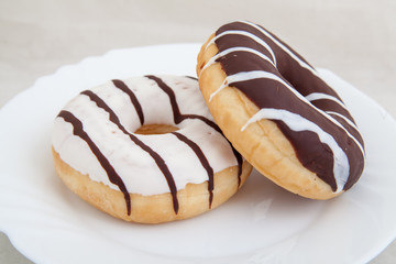 Two fresh donuts on white plate