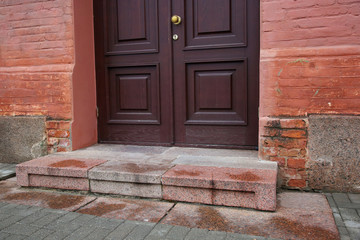 Porch with dark door of red bricked building