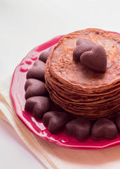 Chocolate pancakes and chocolates in the shape of a heart. Selec