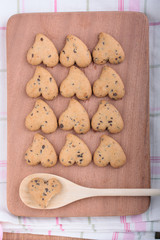 Heart shaped cookies on a chopping board.