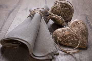 Linen napkin tied by cord with crude wooden heart