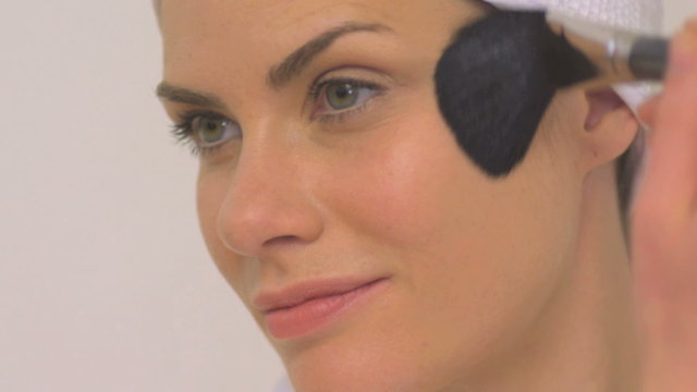 BCU OF A WOMAN APPLYING BLUSHER