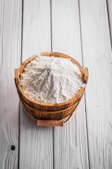 white natural flour in wooden bucket on painted boards food and