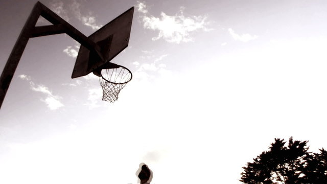 Basketball players dunking basketball in basket, London, UK