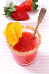 Strawberry smoothie topped with brown sugar, orange slice