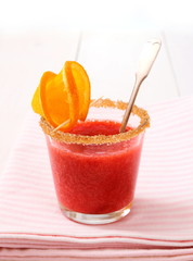 Strawberry smoothie topped with brown sugar, orange slice