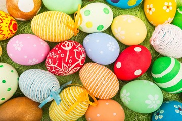 colorful background with easter painted eggs in wicker basket