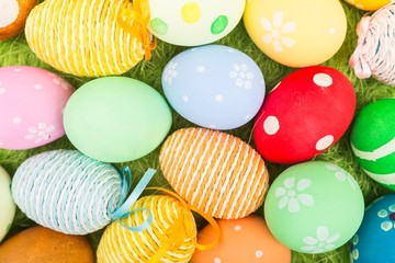 colorful background with easter painted eggs in wicker basket