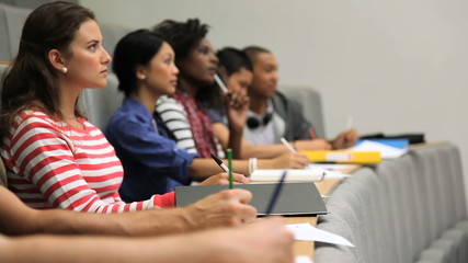 Group of students taking notes in lecture theatre