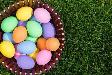 Colorful easter eggs in nest on meadow