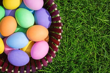 Fototapeta na wymiar Colorful easter eggs in nest on meadow