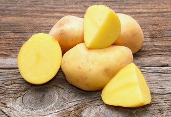 Bunch of potatoes on wooden background