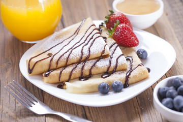 Delicious sweet French pancakes on a plate with fresh fruits
