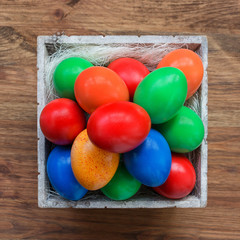 Colorful easter eggs in basket. Top view