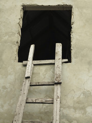 Old wooden vintage cuve ladder near a wall