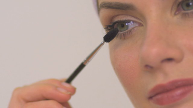 BCU OF A WOMAN APPLYING MASCARA