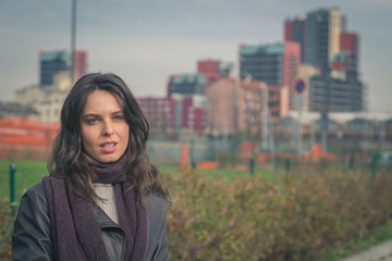 Beautiful young brunette posing in the city streets