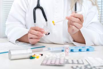 Naklejka premium Healthcare worker makes a daily tray of pills for a patient