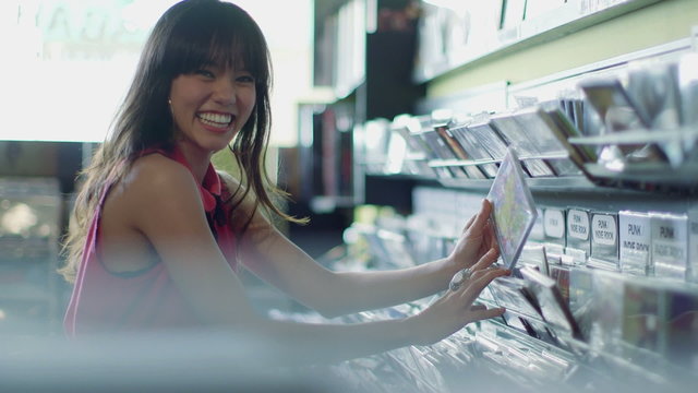 A Young Woman eagerly browses through a selection of vintage records