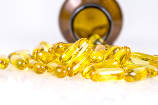 Closeup yellow soft gelatin supplement fish oil capsule