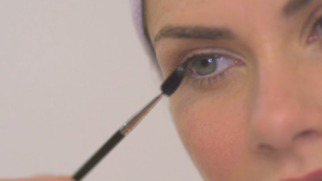 BCU OF A WOMAN APPLYING MASCARA