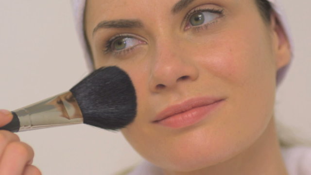 BCU OF A WOMAN APPLYING BLUSHER