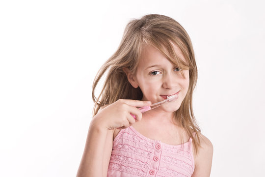 girl with toothbrush, smiling to camera