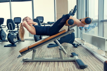 Fototapeta na wymiar Beautiful woman doing press fitness exercise at sport gym