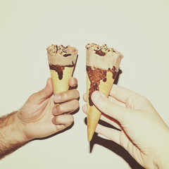 Female and male hands holding ice-creams in cones