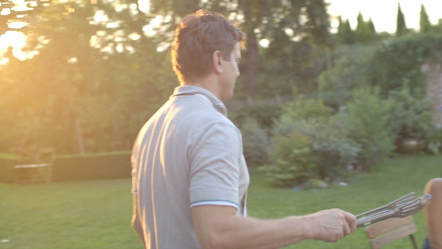 MS TS Husband serves sausages to his wife in domestic garden