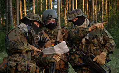 Three german soldiers discuss a plan of action. Coordinate the team.