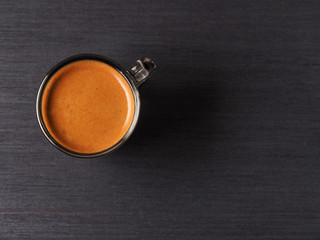 Cup of hot espresso coffee on wood board