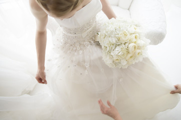 Fototapeta na wymiar Women fix the hem of wedding dress