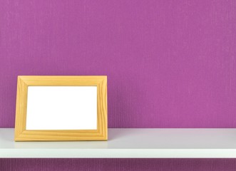 A blank picture frame on a shelf with copy space background