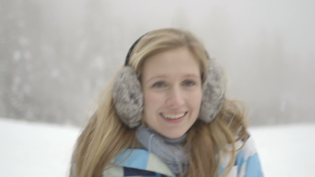 Close up Young woman wearing earmuffs and enjoying in snow