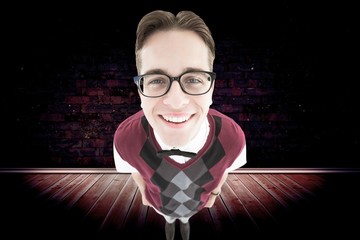 Composite image of smiling geeky hipster looking at camera