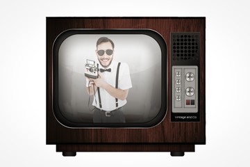 Composite image of geeky hipster holding a retro camera