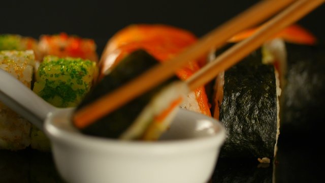Fresh sushi on black table in motion