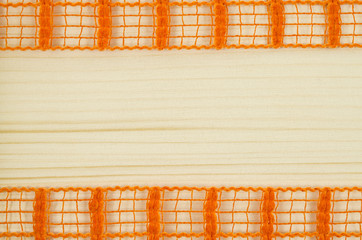 Frame of orange ribbon on wooden background