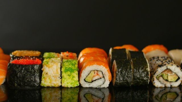 Fresh sushi on black table in motion