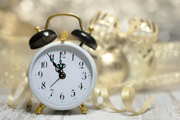 Fototapeta na wymiar Old alarm clock showing five to midnight. Happy New Year!