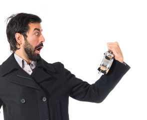 Surprised man holding a clock