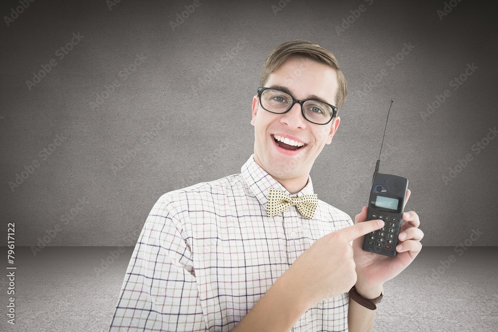 Poster Composite image of geeky hipster holding a retro cellphone