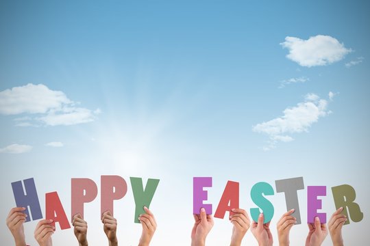 Composite image of hands holding up happy easter