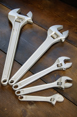 Spanner or adjustable wrench on wooden back ground