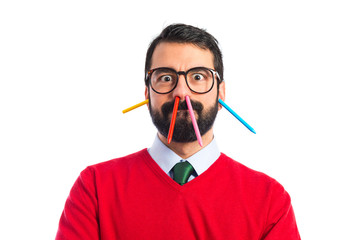 Hipster man with crayons inside his nose and ears